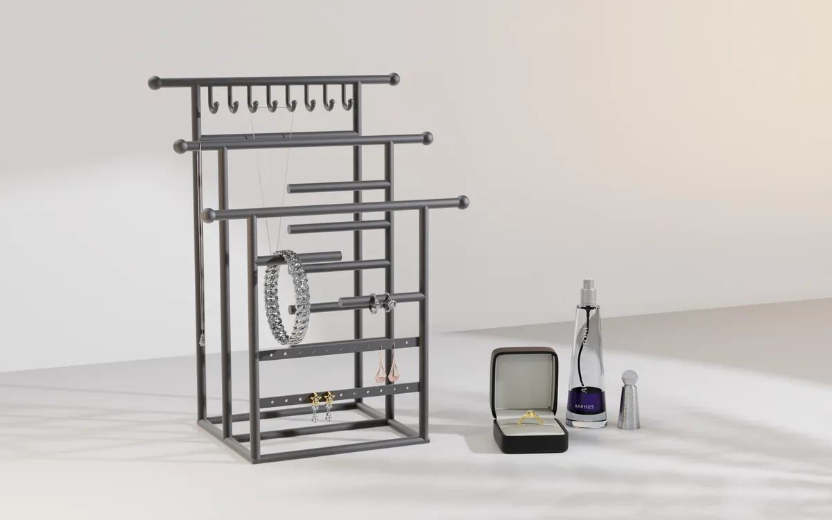 Three-tier telescoping matte black steel Gia Rivera jewellery stand, each crossbar wider than the one above it, styled with a bracelet, rings and earrings.
