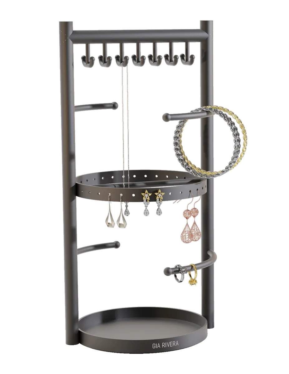 Side profile of a compact rotating Gia Rivera jewellery stand on a round tray base, with hook rail, ring bar and earring pegs around a central post.